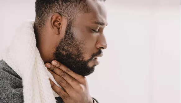 A photo of a man holding his throat
