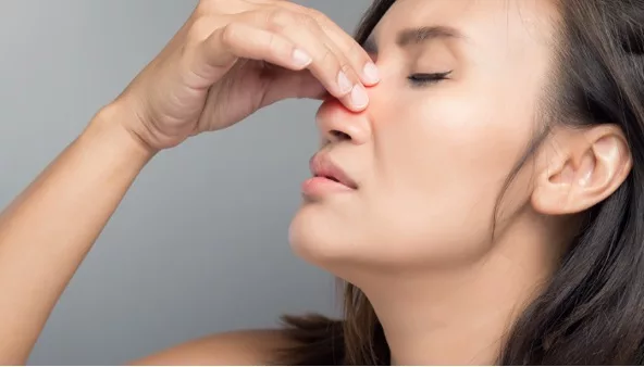 Photo of a woman pinching the bridge of her nose